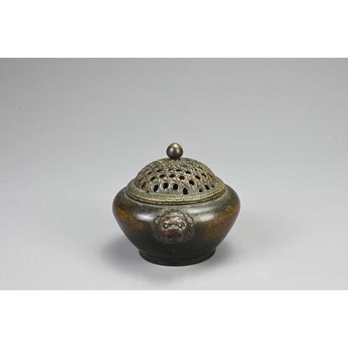 83 - A CHINESE BRONZE CENSER, 20TH CENTURY. Of circular form with twin lion mask handles and pierced cove... 