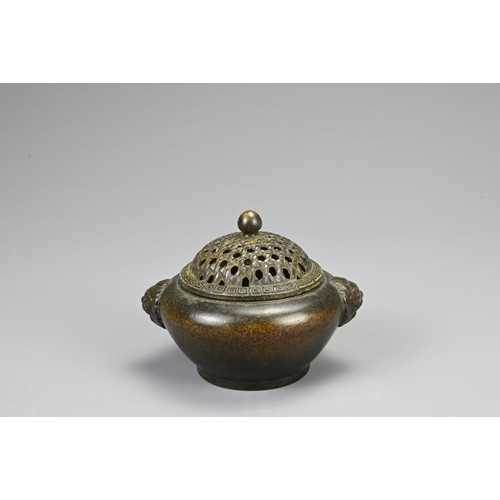 83 - A CHINESE BRONZE CENSER, 20TH CENTURY. Of circular form with twin lion mask handles and pierced cove... 