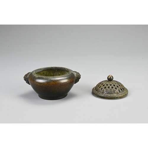 83 - A CHINESE BRONZE CENSER, 20TH CENTURY. Of circular form with twin lion mask handles and pierced cove... 