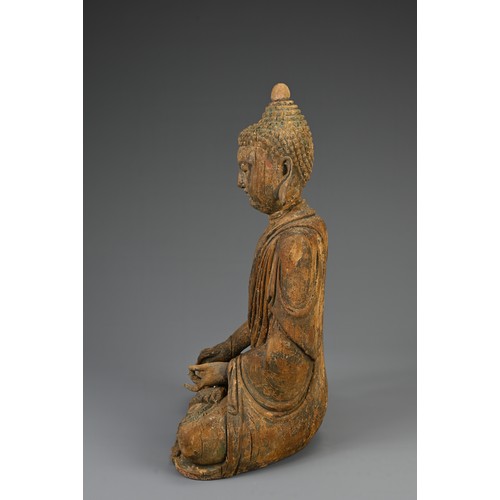 181 - A CARVED WOODEN FIGURE OF SEATED BUDDHA, MING DYNASTY OR LATER. The figure dressed in robes with ser... 