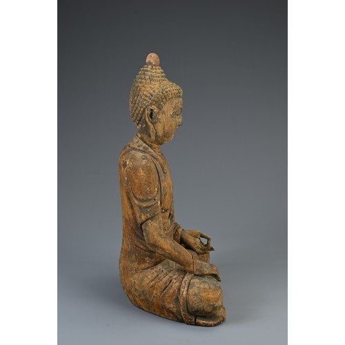 181 - A CARVED WOODEN FIGURE OF SEATED BUDDHA, MING DYNASTY OR LATER. The figure dressed in robes with ser... 