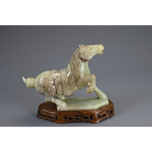 359 - A CHINESE CARVED JADE MODEL OF A PRANCING HORSE, 20TH CENTURY. Mounted on a carved and pierced woode... 