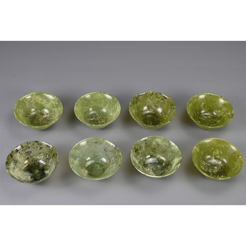 105 - A GROUP OF EIGHT CHINESE SPINACH JADE BOWLS, 19/20TH CENTURY. Each with a rounded body and gently ev... 