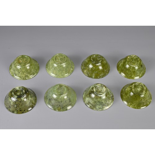 105 - A GROUP OF EIGHT CHINESE SPINACH JADE BOWLS, 19/20TH CENTURY. Each with a rounded body and gently ev... 