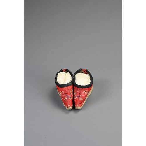 134 - TWO PAIRS OF CHINESE SHOES, EARLY 20TH CENTURY. To include a pair of red ground silk embroidered sho... 