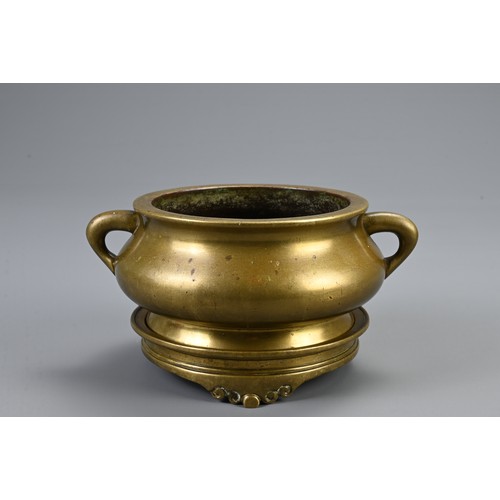 82 - A CHINESE BRONZE CENSER ON STAND, 18/19TH CENTURY. Heavily cast of squat form with twin looped handl... 