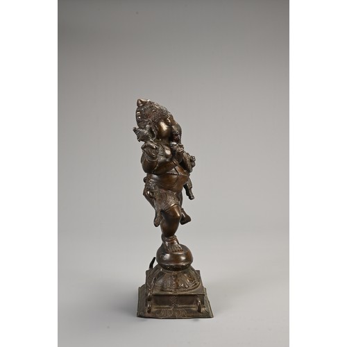 96 - AN INDIAN BRONZE FIGURE OF GANESH WITH CONSORT. heavily cast figure holding ritual items standing on... 