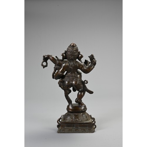 96 - AN INDIAN BRONZE FIGURE OF GANESH WITH CONSORT. heavily cast figure holding ritual items standing on... 