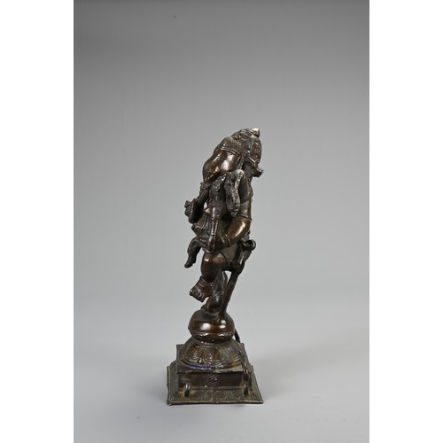 96 - AN INDIAN BRONZE FIGURE OF GANESH WITH CONSORT. heavily cast figure holding ritual items standing on... 