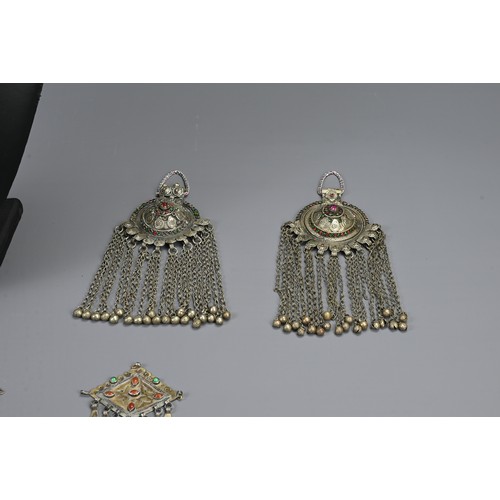 65 - A GROUP OF TURKMAN / INDIAN METAL WARE JEWELLERY ITEMS, 20TH CENTURY. To include a pair of fire gild... 