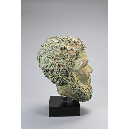 98 - A DECORATIVE CAST BRONZE HEAD. Hollow cast male head, Greek or Roman in style on a display stand. He... 