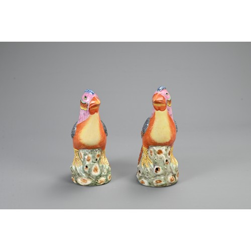 125 - A PAIR OF CHINESE POLYCHROME DECORATED PORCELAIN PHEASANTS, 20TH CENTURY. A mirrored pair perched on... 