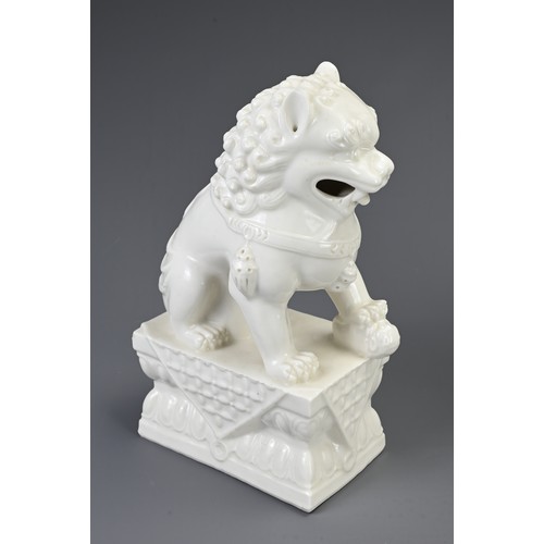 160 - A PAIR OF CHINESE WHITE GLAZED PORCELAIN GUARDIAN LIONS, 20TH CENTURY. Seated on a rectangular form ... 