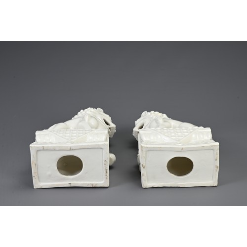 160 - A PAIR OF CHINESE WHITE GLAZED PORCELAIN GUARDIAN LIONS, 20TH CENTURY. Seated on a rectangular form ... 