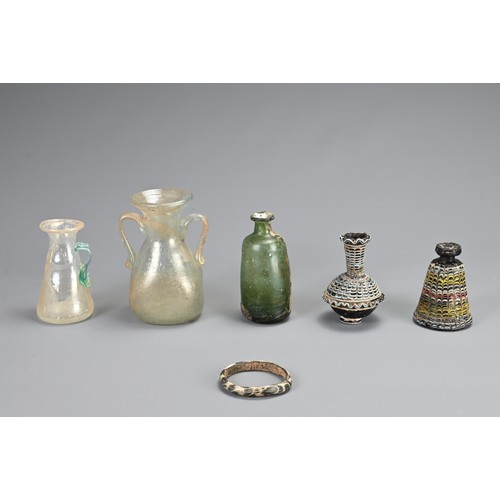 184 - A GROUP OF GLASSWARE ITEMS, PROBABLY ROMAN AND LATER. To include two Phoenician glass vessels; Three... 