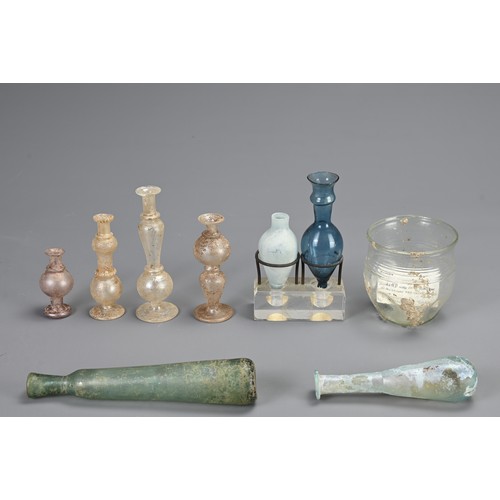 185 - A GROUP OF ROMAN GLASSWARE ITEMS, CIRCA 1-5 CENTURY AD. Of various forms to include a clear glass be... 