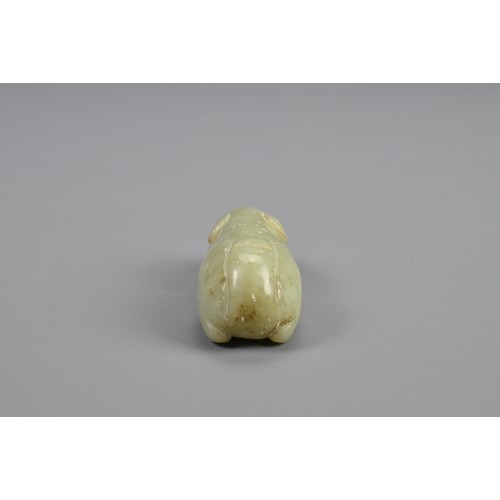 109 - A CHINESE CELADON JADE RECUMBENT BOAR PENDANT, 18/19TH CENTURY. Dense jade carved in the form of a b... 