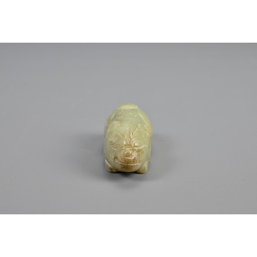 109 - A CHINESE CELADON JADE RECUMBENT BOAR PENDANT, 18/19TH CENTURY. Dense jade carved in the form of a b... 