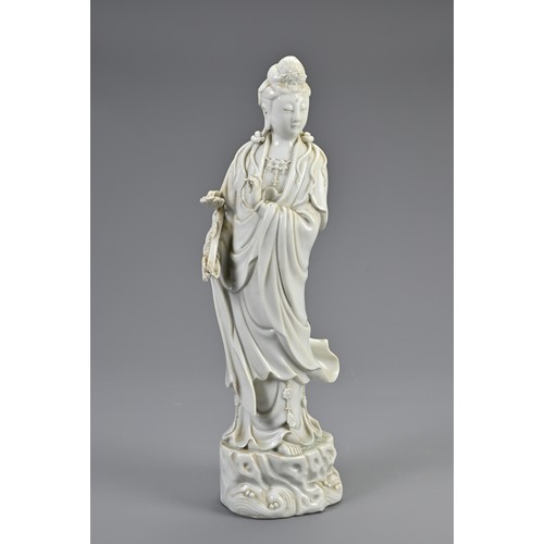 140 - A CHINESE BLANC DE CHINE PORCELAIN FIGURE OF GUANYIN, 20TH CENTURY. Standing figure dressed in robes... 