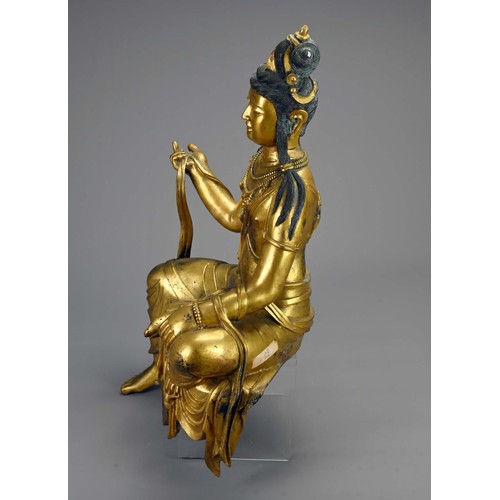 189 - A LARGE TIBETAN GILT BRONZE FIGURE OF GUANYIN. The Bodhisattva seated in royal ease pose holding sec... 