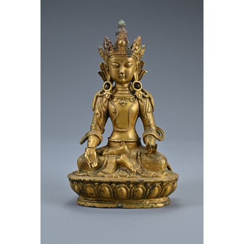 188 - A TRIO OF TIBETAN BRONZE SEATED BUDDHAS ON STAND. The deities dressed in robes adorned with jewels o... 