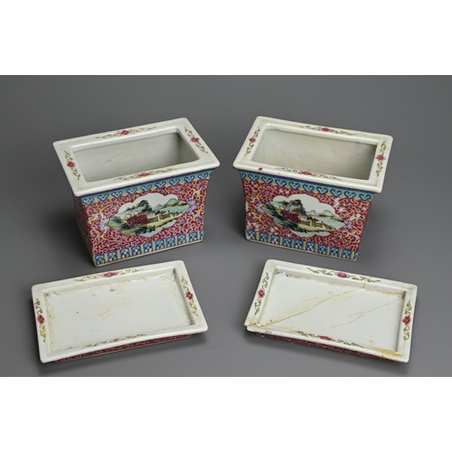 28 - A PAIR OF CHINESE RUBY GROUND AND FAMILLE ROSE DECORATED PORCELAIN JARDINIERES ON STANDS, 20TH CENTU... 