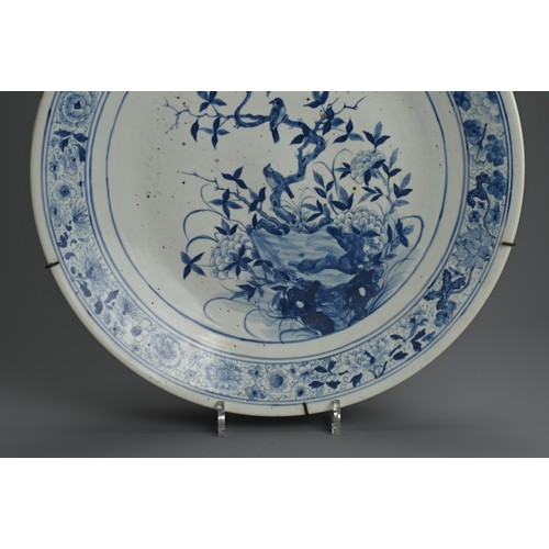 102 - A LARGE CHINESE BLUE AND WHITE PORCELAIN CHARGER, 19TH CENTURY. Finely decorated with birds perched ... 