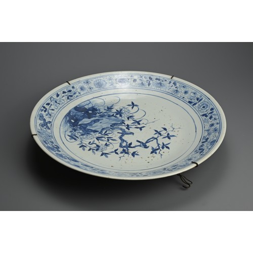 102 - A LARGE CHINESE BLUE AND WHITE PORCELAIN CHARGER, 19TH CENTURY. Finely decorated with birds perched ... 