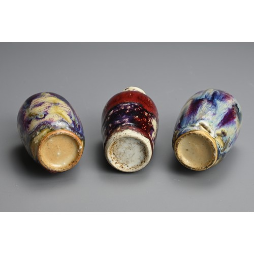 138 - THREE CHINESE FLAMBE GLAZED MINIATURE PORCELAIN BOTTLES, 19/20TH CENTURY. To include a pair of ovoid... 