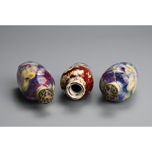 138 - THREE CHINESE FLAMBE GLAZED MINIATURE PORCELAIN BOTTLES, 19/20TH CENTURY. To include a pair of ovoid... 