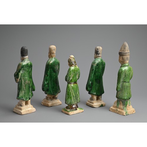 155 - A GROUP OF CHINESE SANCAI GLAZED POTTERY FIGURES OF ATTENDANTS, MING DYNASTY. Four male and one fema... 