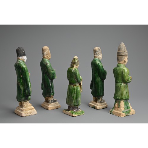 155 - A GROUP OF CHINESE SANCAI GLAZED POTTERY FIGURES OF ATTENDANTS, MING DYNASTY. Four male and one fema... 