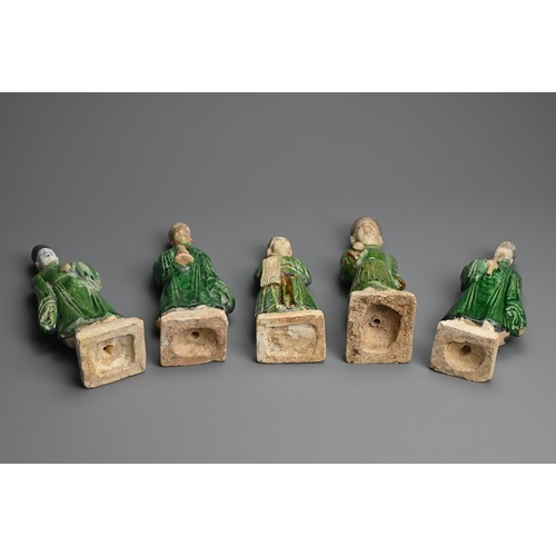 155 - A GROUP OF CHINESE SANCAI GLAZED POTTERY FIGURES OF ATTENDANTS, MING DYNASTY. Four male and one fema... 