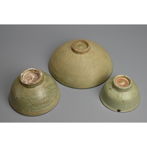 180 - THREE CHINESE LONGQUAN CELADON GLAZED BOWLS, YUAN / MING DYNASTY. Of various sizes covered in green ... 