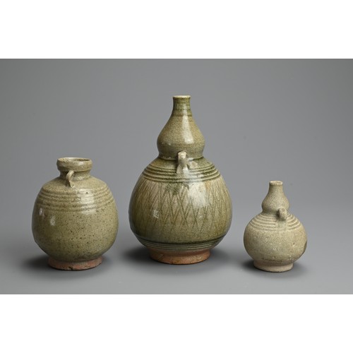 199 - THREE THAI SAWANKHALOK CELADON GLAZED STONEWARE VASES, CIRCA 15TH CENTURY. Two double gourd form vas... 