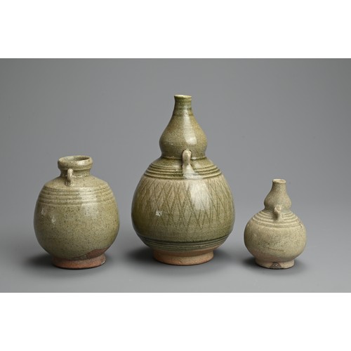 199 - THREE THAI SAWANKHALOK CELADON GLAZED STONEWARE VASES, CIRCA 15TH CENTURY. Two double gourd form vas... 