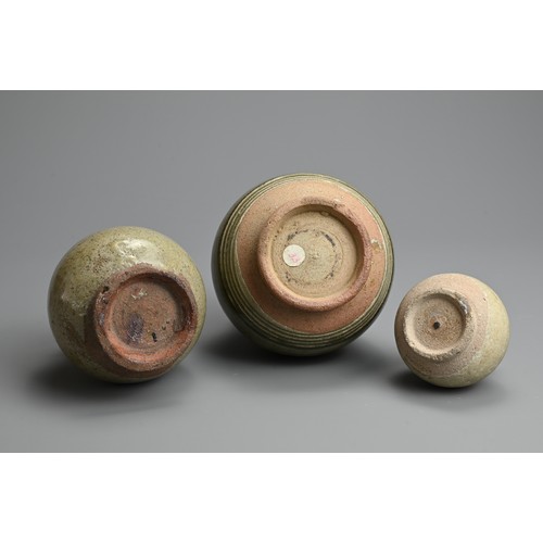 199 - THREE THAI SAWANKHALOK CELADON GLAZED STONEWARE VASES, CIRCA 15TH CENTURY. Two double gourd form vas... 