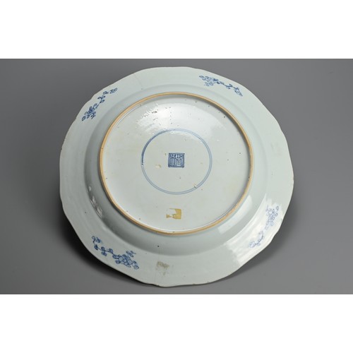 217 - A LARGE CHINESE BLUE AND WHITE PORCELAIN DISH, 18TH CENTURY. With lobed sides decorated with buildin... 