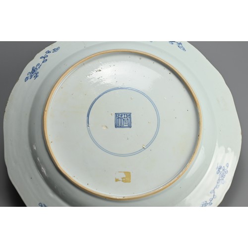 217 - A LARGE CHINESE BLUE AND WHITE PORCELAIN DISH, 18TH CENTURY. With lobed sides decorated with buildin... 