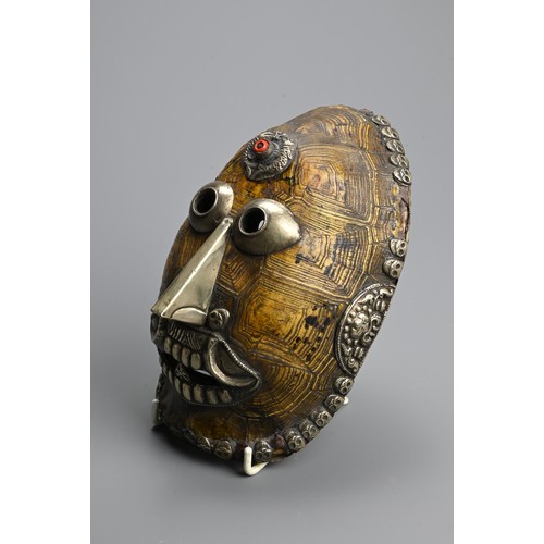 231 - A TIBETAN TURTLE SHELL KAPALA MASK, 19/20TH CENTURY. The shell mounted with white metal facial featu... 