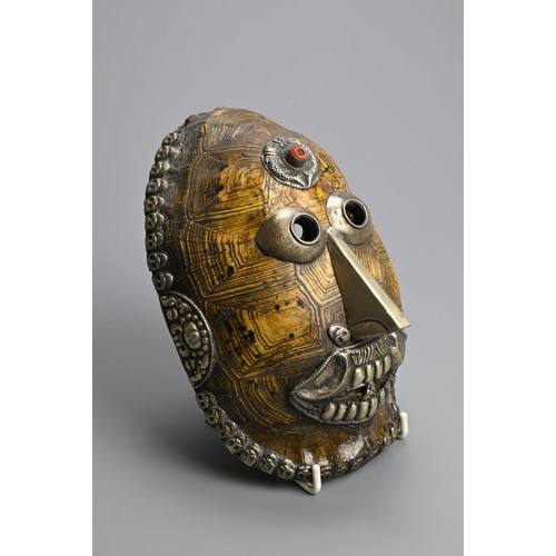 231 - A TIBETAN TURTLE SHELL KAPALA MASK, 19/20TH CENTURY. The shell mounted with white metal facial featu... 