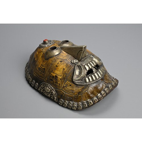 231 - A TIBETAN TURTLE SHELL KAPALA MASK, 19/20TH CENTURY. The shell mounted with white metal facial featu... 