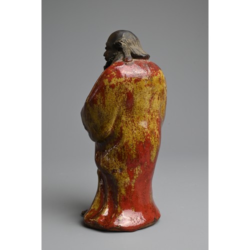 249 - A CHINESE GLAZED SHIWAN POTTERY MODEL OF DAMO, 19/20TH CENTURY. Standing bare foot dressed in robe, ... 