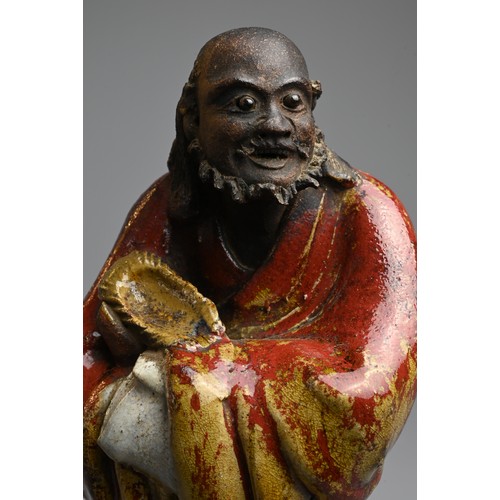 249 - A CHINESE GLAZED SHIWAN POTTERY MODEL OF DAMO, 19/20TH CENTURY. Standing bare foot dressed in robe, ... 