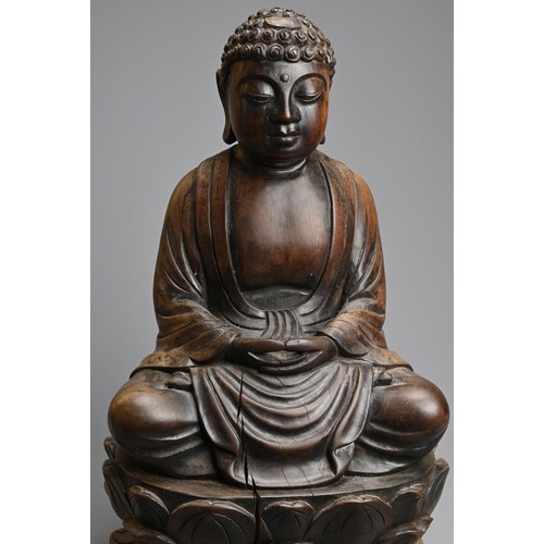 254 - A CARVED WOODEN FIGURE OF BUDDHA, 20TH CENTURY. Dressed in robes seated on a lotus base. 40.5cm tall... 