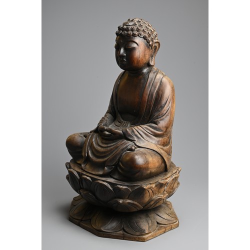 254 - A CARVED WOODEN FIGURE OF BUDDHA, 20TH CENTURY. Dressed in robes seated on a lotus base. 40.5cm tall... 