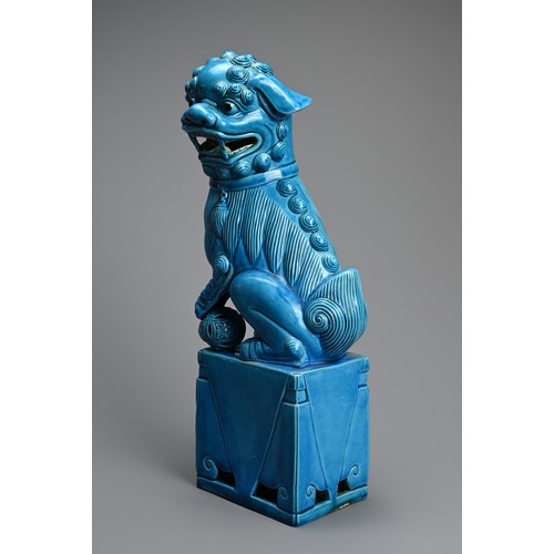 317 - A LARGE CHINESE TURQUOISE GLAZED PORCELAIN FOO DOG, 20TH CENTURY. Seated on a square form stand with... 