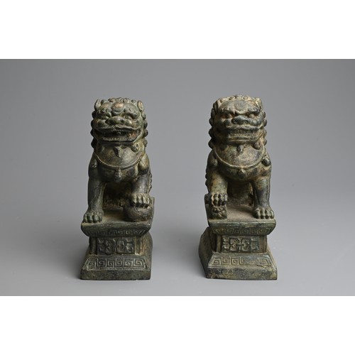 266 - A PAIR OF BRONZE MODELS OF GUARDIAN LIONS, 20TH CENTURY. The male and female lions seated on a raise... 