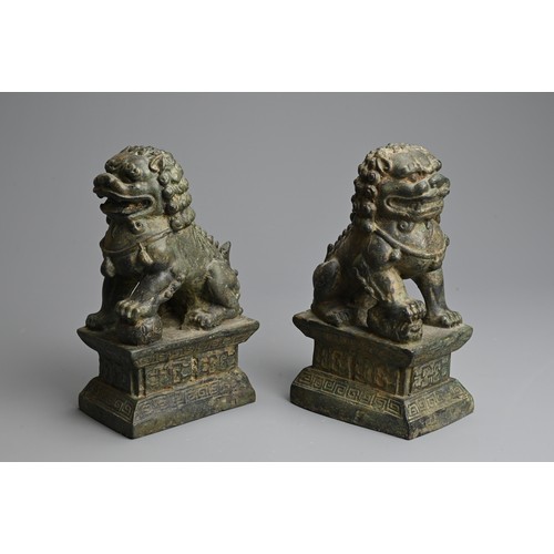 266 - A PAIR OF BRONZE MODELS OF GUARDIAN LIONS, 20TH CENTURY. The male and female lions seated on a raise... 