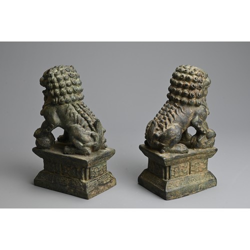 266 - A PAIR OF BRONZE MODELS OF GUARDIAN LIONS, 20TH CENTURY. The male and female lions seated on a raise... 